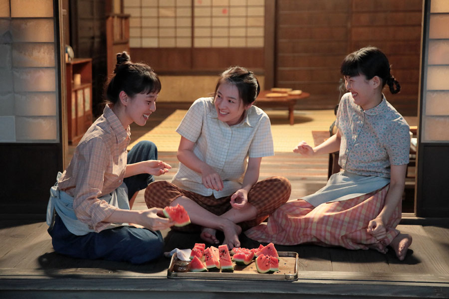 左から喜美子(戸田恵梨香)、直子(桜庭ななみ)、百合子(福田麻由子)。スイカを食べながら直子の就職先のことを話す三姉妹©NHK