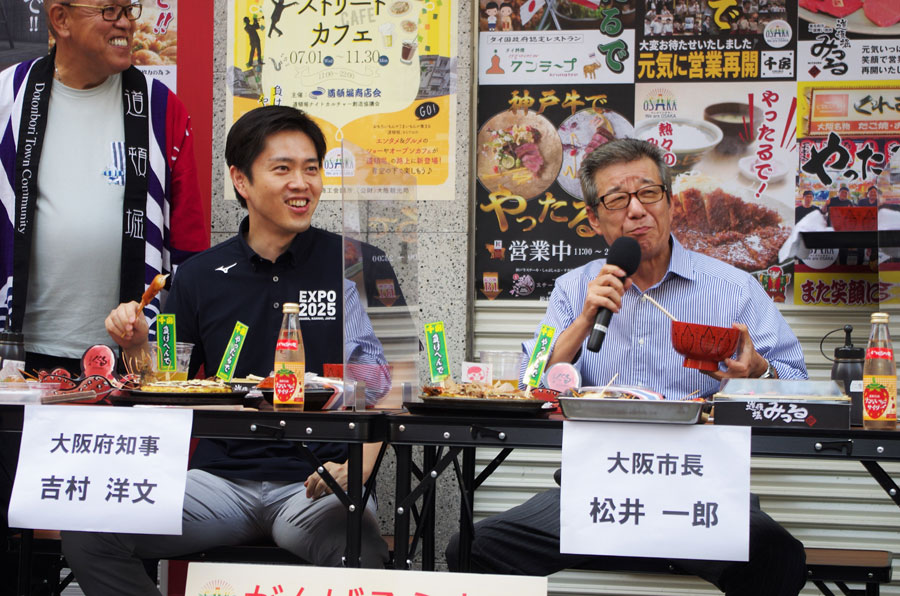 息の合った掛け合いで会場を盛り上げる吉村洋文知事（左）と松井一郎市長（７月１日・大阪市内）