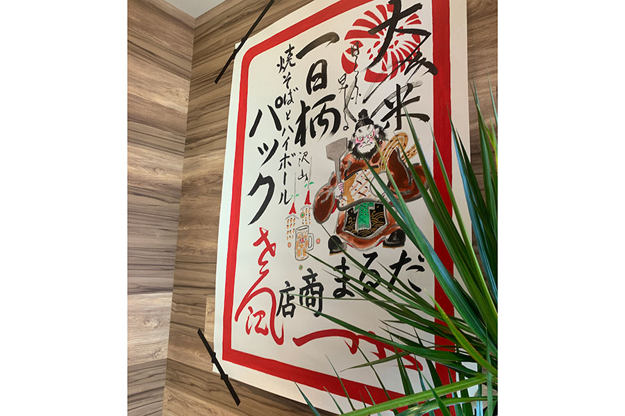 舞妓さんがデビューする時に置屋の玄関先に貼られる「お日柄」。入り口には、京都の絵描きユニット「だるま商店」からの開店祝いとしてお日柄が貼られている