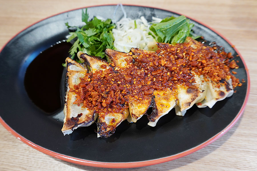 特製の麻辣がたっぷりかかった「スパイス餃子」（４８０円）は、水菜・ネギ・パクチーが薬味として付けられている