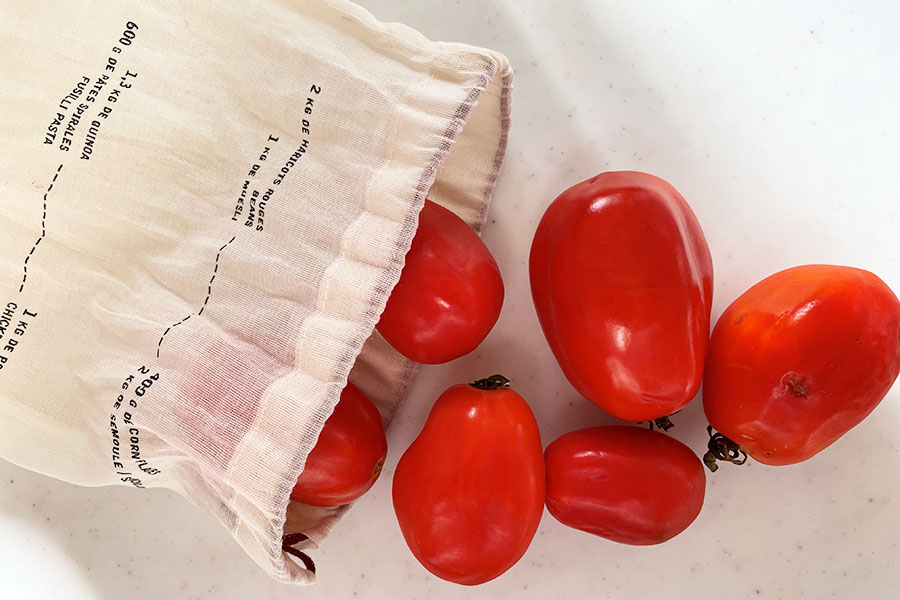 写真は三重県のAINA FARMで生産された、サンマルツァーノ種トマト。なお、店内の食料品は一部を除き、全てオーガニック。野菜コーナーには契約農家の紹介も