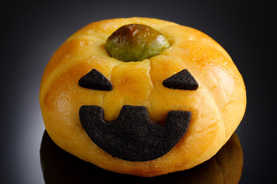 【カフェ＆グルメショップ カフェベル】かぼちゃの餡がたっぷり入った「かぼちゃのおばけパン」（300円）。ココア風味の目と口がポイント。 
