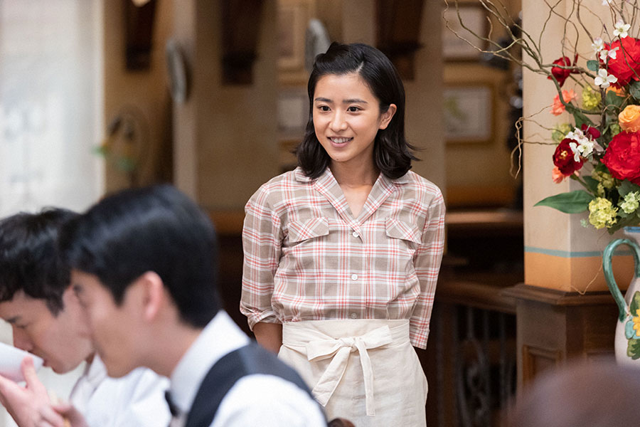 レストランの従業員たちが食べる姿を笑顔で見つめる比嘉暢子（黒島結菜）(C)NHK