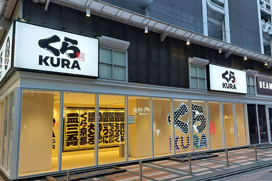 「くら寿司 京都店」の外観（夜の様子）。街行く人も写真撮影ができるロゴネオンサイン
