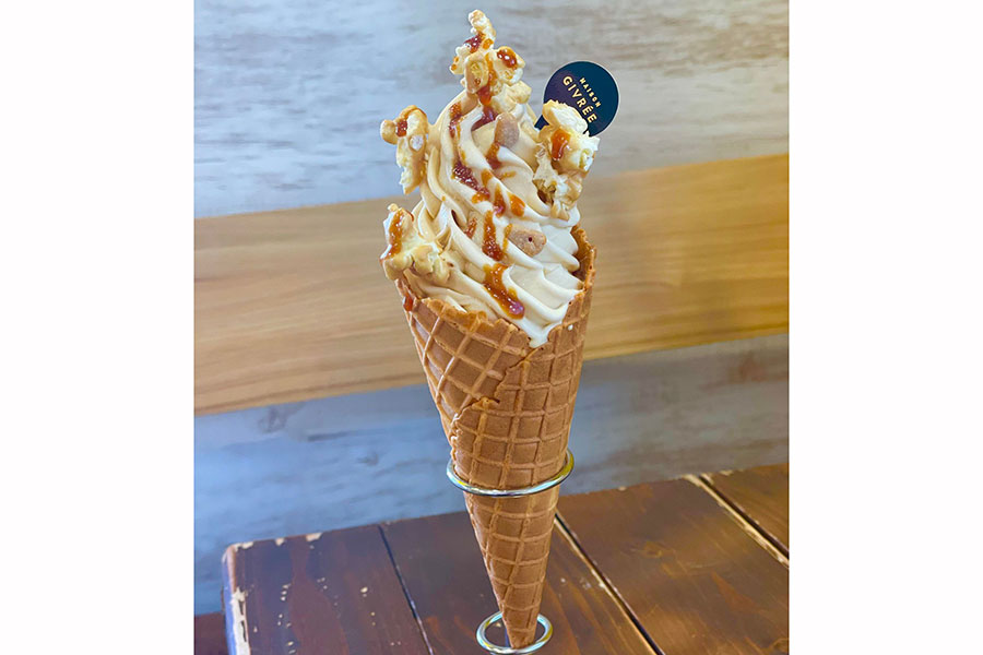 ゴールドチョコレートのソフトクリームの上に、白いとうもろこしのソフトクリームを乗せた「ロイシー ゴールド プレミアム・ザ・ジブレー」（800円／メゾン ジブレー）。仕上げにポップコーンとキャラメルソースをトッピング。