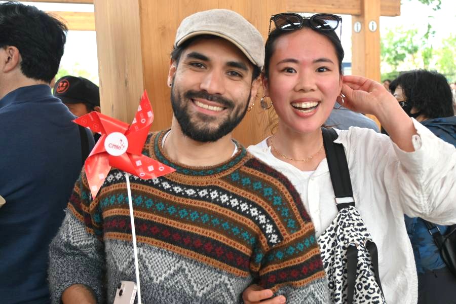 パレードを楽しんでいた来場者たち。日本在住のチリ人の男性が持つのは、ナショナルデーを記念し来場者に配られた風車(撮影5月12日:大阪・関西万博)