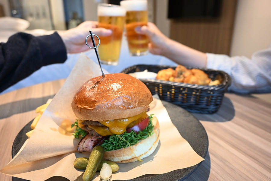 客室でのゆっくりインルームダイニング(11:30~22:00)。ビール(1000円~)と楽しみたい、大阪・本町オリジナル「マリオットバーガー」(2400円)など、和洋メニューは20種以上