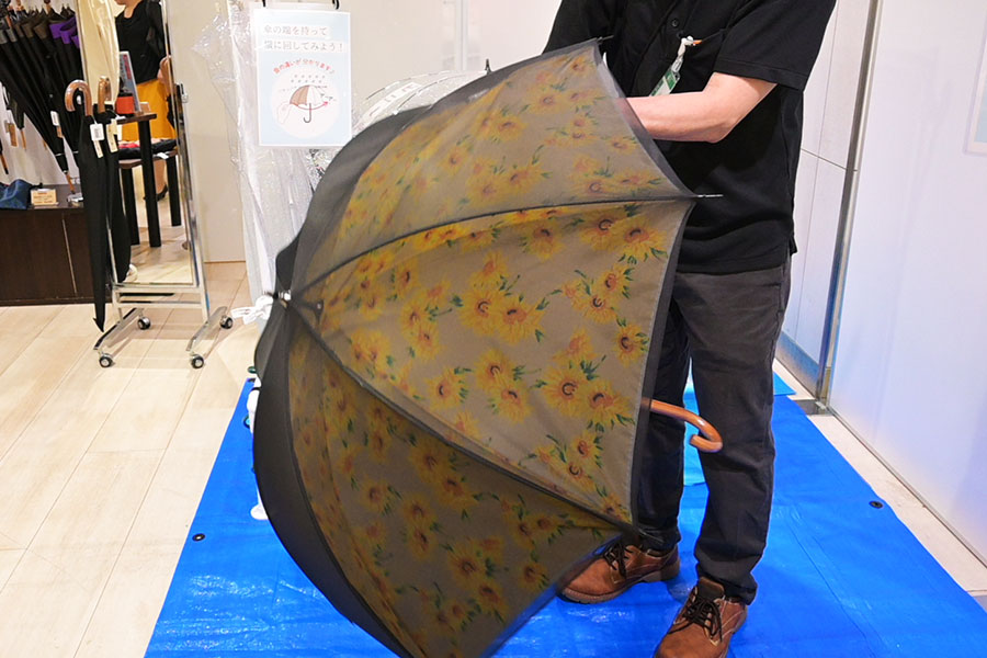 「丸安洋傘」の晴雨兼用長傘(1万9800円)。 視覚障がいの方からの声で作られたサイレントアンブレラ。二重構造で雨滴の音を軽減し、周りの音も聞き取りやすく。職人が手作りで作り上げる。売場で実際に雨音の変化を体験できるブースも