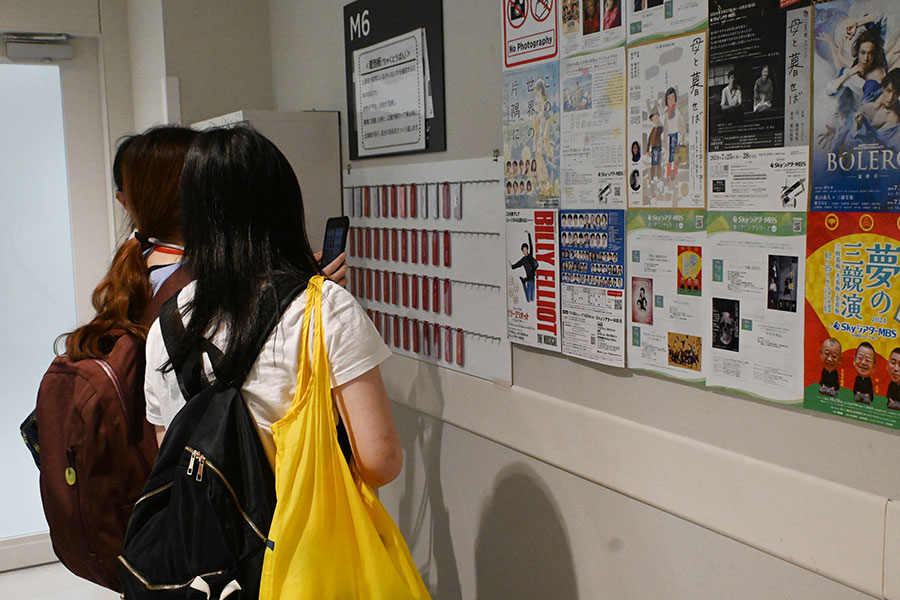 楽屋の着到板で自分の名前を確認する見学者たち(撮影:Lmaga.jp)