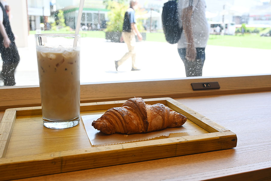 カウンター席にはコンセントも完備。「濃縮カスタムミルクラテ」(600円)、「国産発酵バターのクロワッサン」(291円~)などパン類も