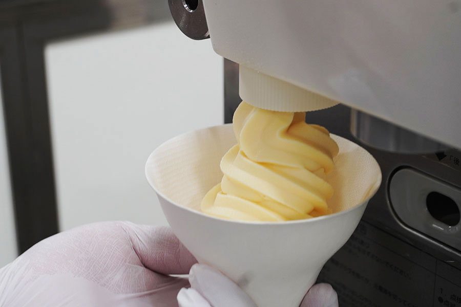 「プリン研究所」のソフトクリーム形のプリンがマシンから出てくる様子。これでプリン1個分ほどだそう