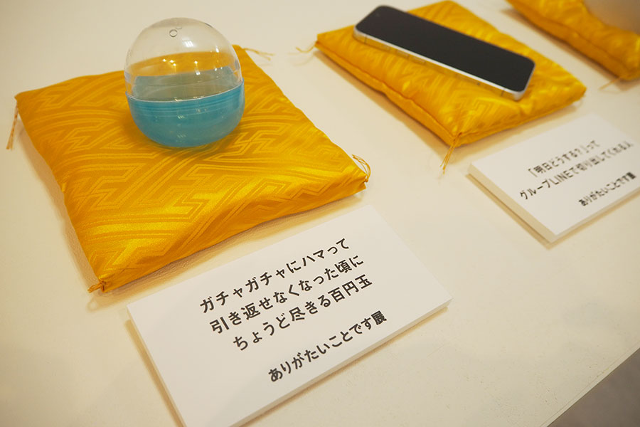 トイカプセルやスマホなどの小物展示もあり、添えられたシチュエーション文に注目