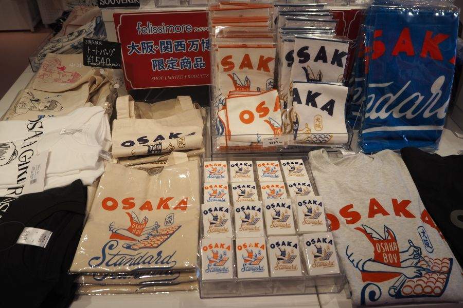 「felissimore 大阪・関西万博店」限定のTシャツ(2750円)、「ビッグマグネットクリップ」(550円)など(撮影9月9日:大阪・関西万博)