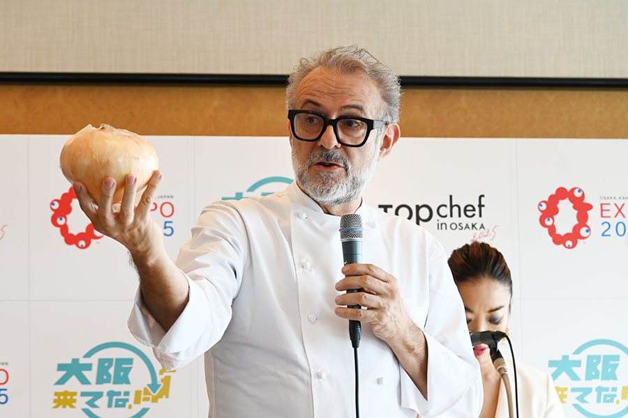 射手矢農園(泉佐野)の「プレミアム泉州たまねぎ」を持ちながら、大阪食材について熱く語るマッシモ・ボットゥーラシェフ(9月11日/ホテルニューオータニ大阪)