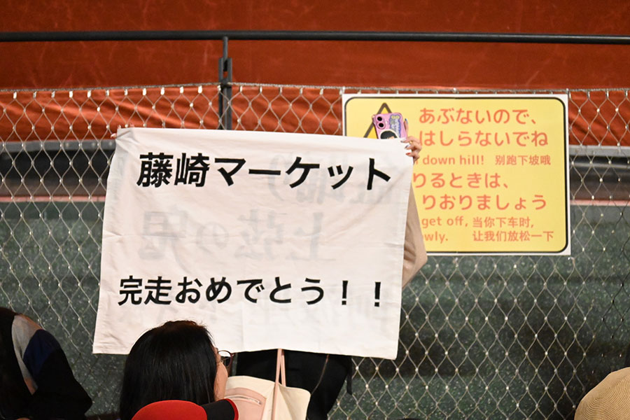 「盆踊りのアシタ」のフィナーレ、盆踊り神4として盛り上げに貢献した藤崎マーケットにメッセージを掲げる人も(10月13日/大阪・関西万博)