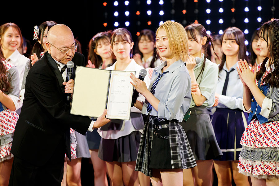 三 代目キャプテンの任命証を渡される塩月希依音 ©NMB48