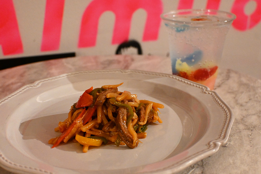 左から、作品『ウィーアーリトルゾンビーズ』とコラボしたカナシミ チンジャオロース(1210円)、ウィーアーリトルゾンビーズカラーソーダ(1100円)。コラボ商品は上映期間中のみ販売