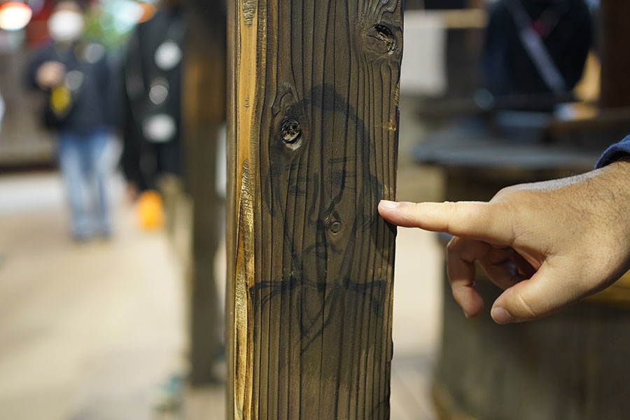 「『ばけばけ』セット公開」の様子。井戸の柱に描かれた、トキの祖父・勘右衛門(小日向文世)と思しき落書き(2月19日撮影/Lmaga.jp)