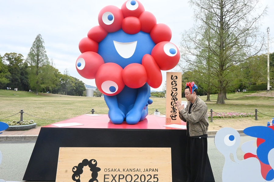 「万博記念公園」のミャクミャク像に『あいわずぼーんとぅ盆踊り』のリリースを伝えるレイザーラモンRG(4月13日・Lmaga.jp撮影)