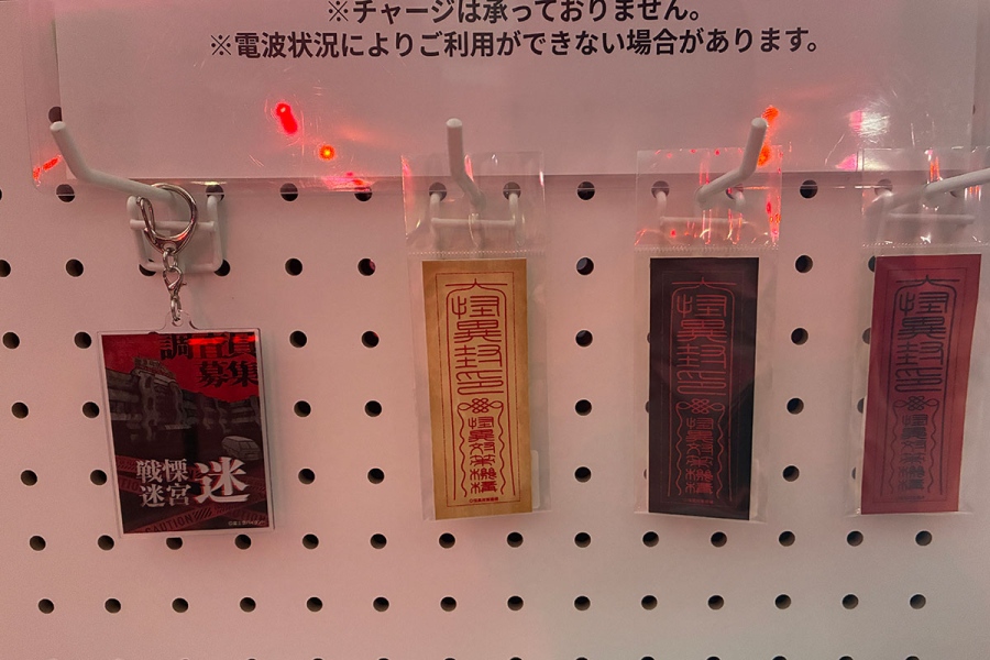 senritsumeikyu_sadako10 | Lmaga.jp 受付ではシャツやキーホルダー、ミニステッカーなどグッズも販売。右にある3種の「戦慄除けのお札 ミニステッカー」(各色500円)を購入すれば「怪異なし」バージョンに切り替え可能。グッズ目当てのため、怪異なしを断る人もいるそう