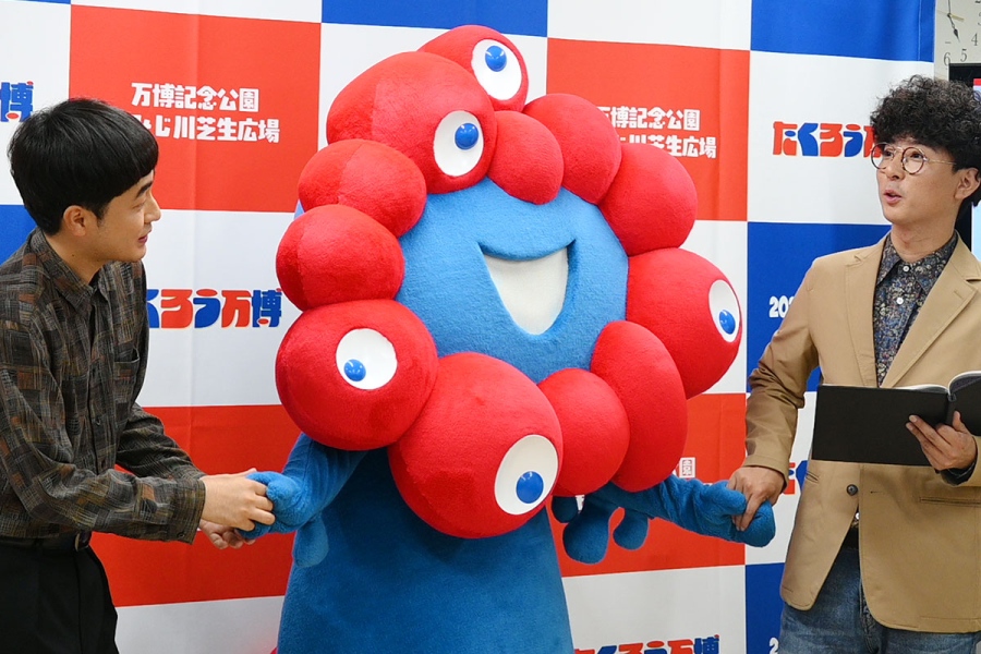 『たくろう万博』の会見で、ミャクミャクと手を繋ぐ(左から)赤木、きむらバンド(7月3日・大阪市内)