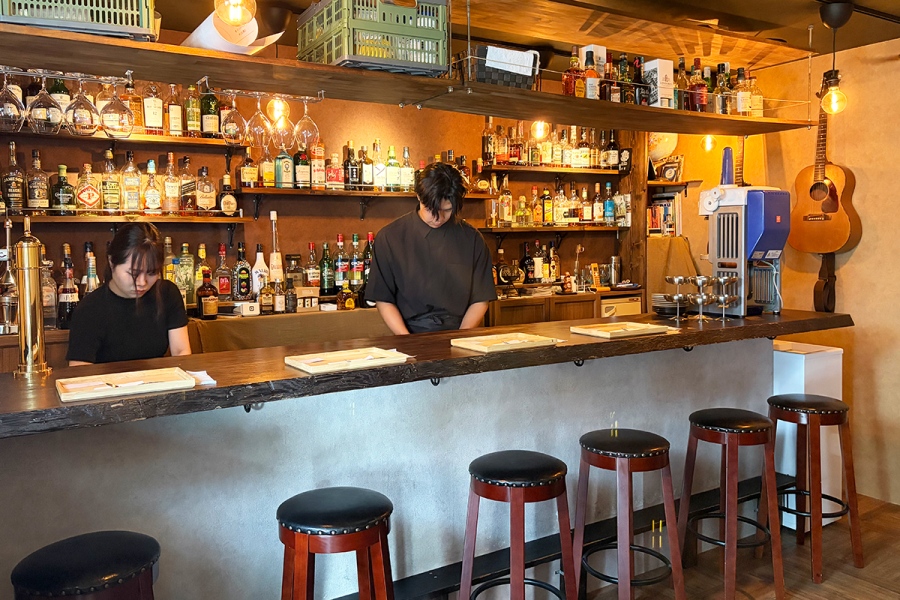 koorinokumo2026_0814_12 | Lmaga.jp 「氷ノ雲」店内。バーを間借りしているため壁一面にアルコールがずらりと並び、薄明かりでムーディーな雰囲気が漂う(Lmaga.jp撮影)