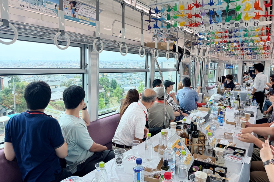 shochuressha0829_3 | Lmaga.jp 大阪モノレール『焼酎列車』の様子。島熊山からの景色を写真撮影する参加者(8月29日)