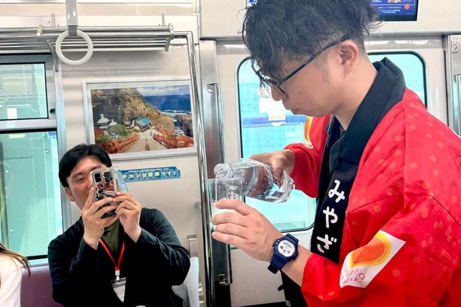 shochuressha0829_5 | Lmaga.jp 大阪モノレール『焼酎列車』の様子。丁寧にソーダを注ぐ「ニシタチソーダワリラボ」の大下マサフミさん(8月29日)