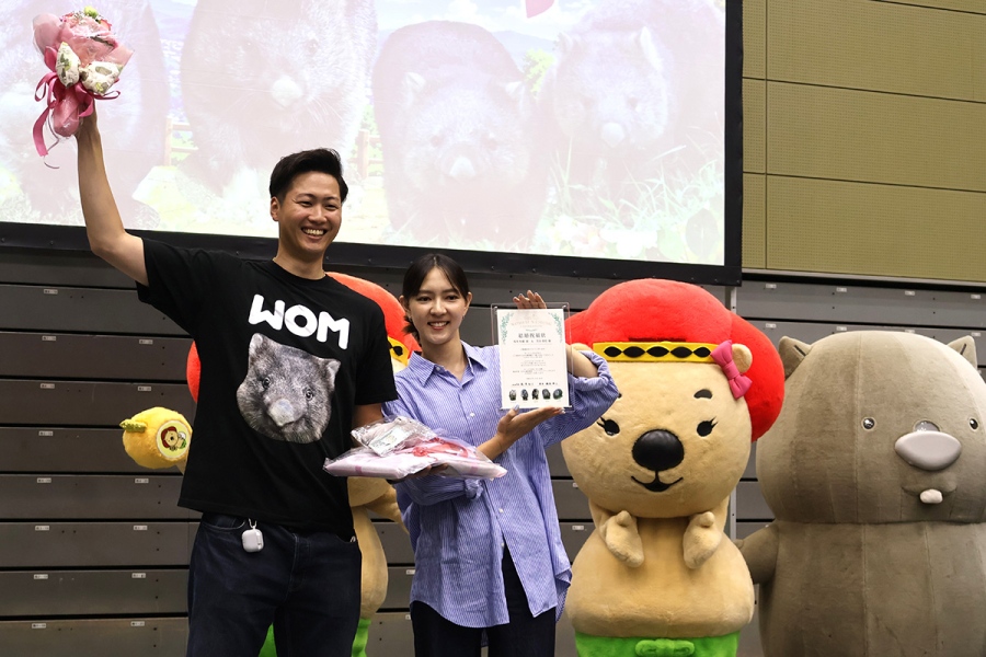 wombat_wedding9 | Lmaga.jp 「ウォンバット課(自称)」から贈呈された花束を掲げる坂本さん・芳谷さんカップル(10月18日撮影、五月山体育館)